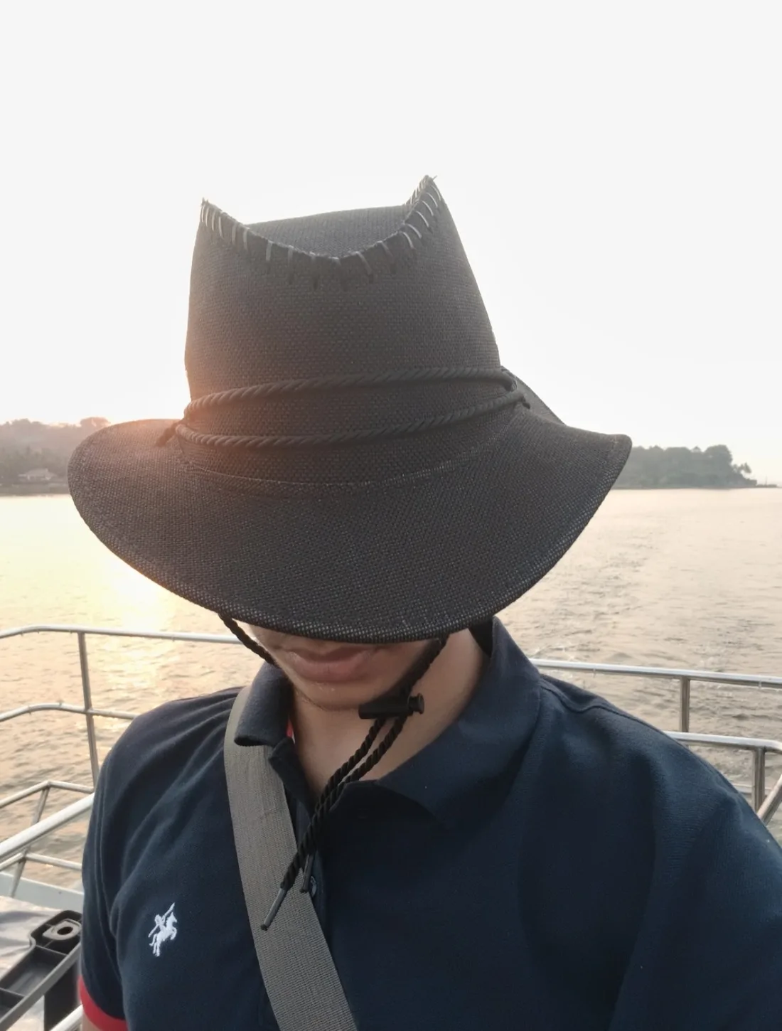 Hardik on a boat, face hidden under a wide brim hat